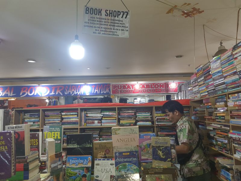 Hendrik menata buku di tokonya yang terletak di basement Blok M Square. Foto: Qonita Azzahra.