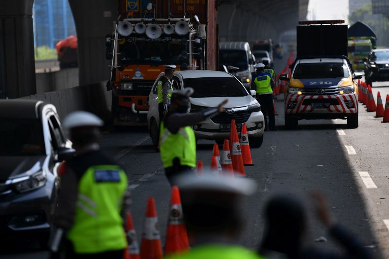 Petugas kepolisian mengarahkan kendaraan pribadi di tol Jakarta-Cikampek untuk memutar balik di pintu tol Cikarang Barat, Jawa Barat, Kamis (7/5/2020). Foto Antara/Sigid Kurniawan.