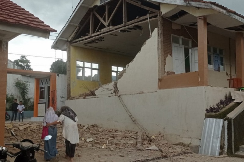 Warga melintasi rumah yang rusak karena gempa di Cianjur, Jawa Barat, Senin (21/11). /Foto dok. BNPB