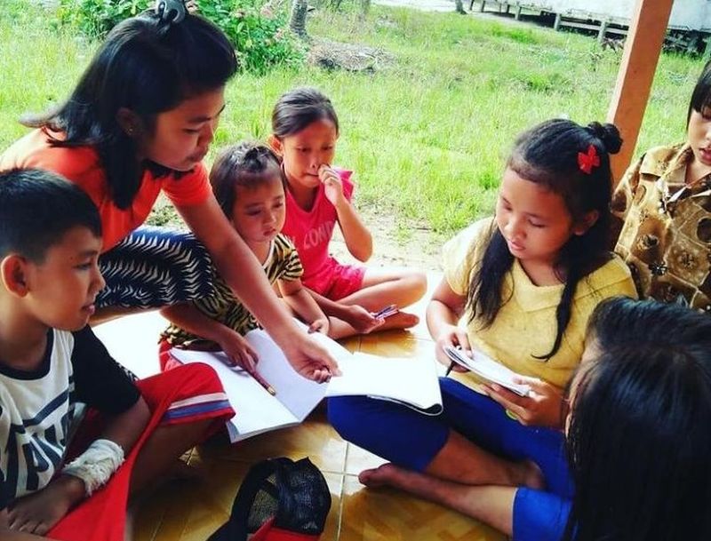 Salah seorang inisiator sekolah adat Samabue di Menjalin, Kalimantan Barat, Yosita tengah memberi materi pelajaran kepada anak-anak komunitas adat Menjalin, Kalimantan Barat. Foto dok. Yosita.