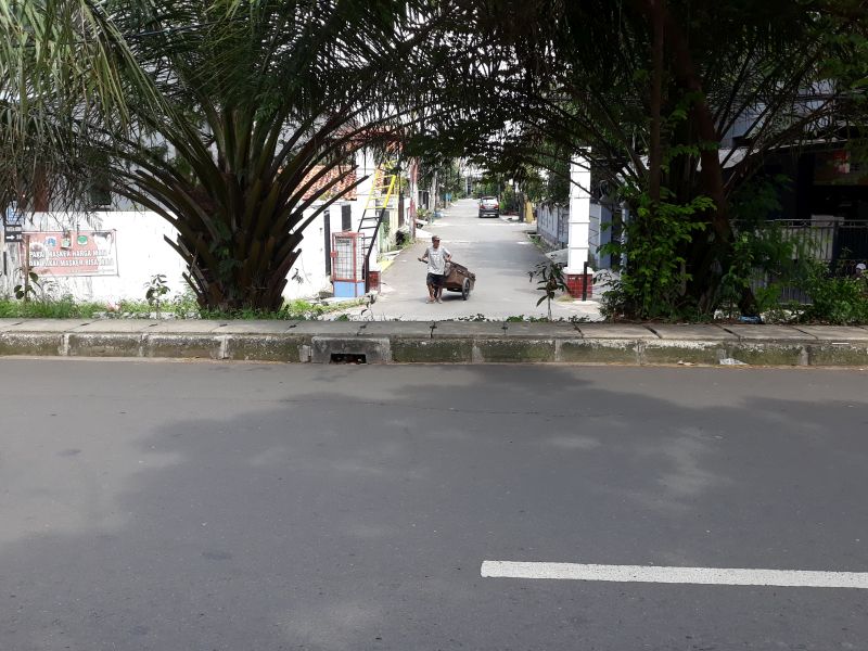 Seorang pemulung melintas di Jalan Kristal Kompleks Permata atau Kampung Ambon, Cengkareng, Jakarta Barat, Selasa (6/12/2022). Alinea.id/Akbar Ridwan