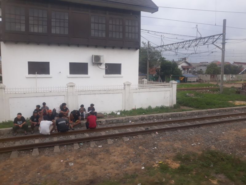 Sekelompok remaja sedang berkumpul di rel kereta api yang memisahkan Kampung Bahari dengan Kampung Muara Bahari, Tanjung Priok, Jakarta Utara, Selasa (6/12/2022). Alinea.id/Akbar Ridwan
