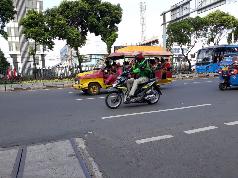 Mobil odong-odong melintas di antara pengemudi ojek daring dan bajaj di Jalan Matraman Raya, Jakarta Timur, Senin (1/8/2022). Alinea.id/Akbar Ridwan.
