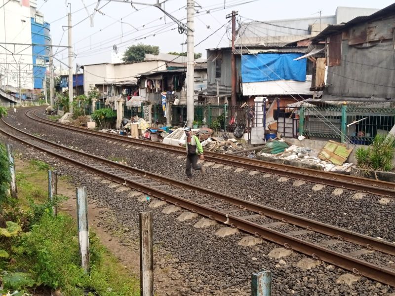 Seorang warga nekat melintas rel kereta api di daerah Kampung Bandan, Jakarta Utara, Selasa (8/3/2022). Alinea.id/Kudus Purnomo Wahidin.