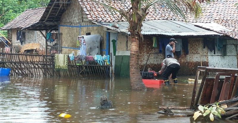Dua orang warga tengah sibuk menyedot air menggunakan sebuah alat di tengah banjir rob yang menerjang Pulau Pari, Kepulauan Seribu, DKI Jakarta, Sabtu (4/12/2021)./Foto dok. Arif Pujianto. 