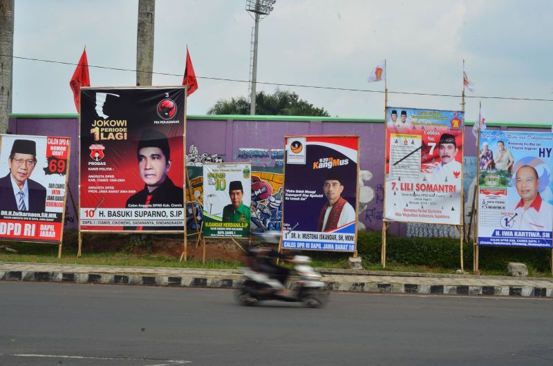 Pengendara sepeda motor melintas di depan deretan alat peraga kampanye caleg tidak berizin di depan Stadion Galuh, Kabupaten Ciamis, Jawa Barat, Jumat (2/11/2018)./Foto Antara/Adeng 