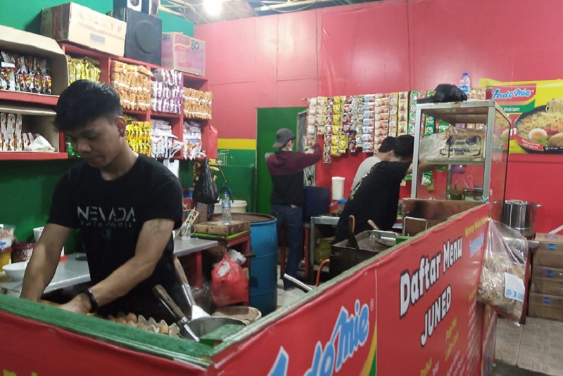 Pekerja menyiapkan makanan untuk pengunjung di Warmindo Juned di di Jalan Kebahagiaan, Krukut, Taman Sari, Jakarta Barat, Jumat (23/12). Alinea.id/Kudus Purnomo Wahidin
