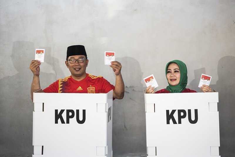 Gubernur Jawa Barat Ridwan Kamil bersama istri menunjukkan surat pencoblosan pada Pilgub Jabar 2018. /Foto Antara