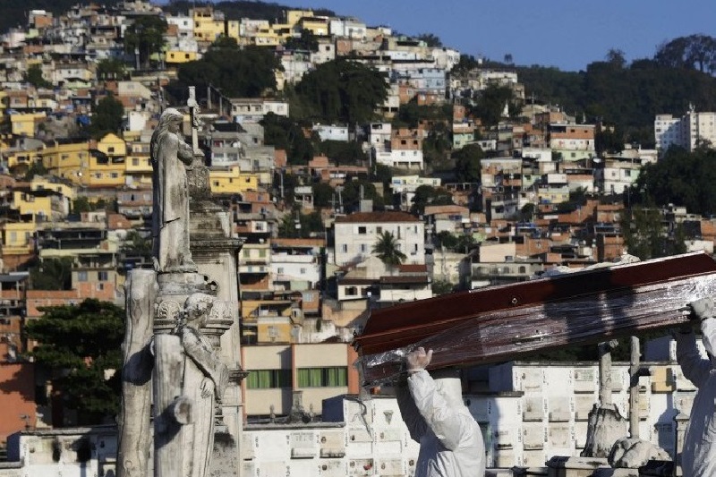 Penggali kubur membawa peti jenazah Avelino Fernandes Filho, 74 tahun, saat pemakamannya yang meninggal dunia akibat penyakit virus korona (COVID-19) di Rio de Janeiro, Brazil, Senin (18/5). Foto Antara/Reuters/Ricardo Moraes