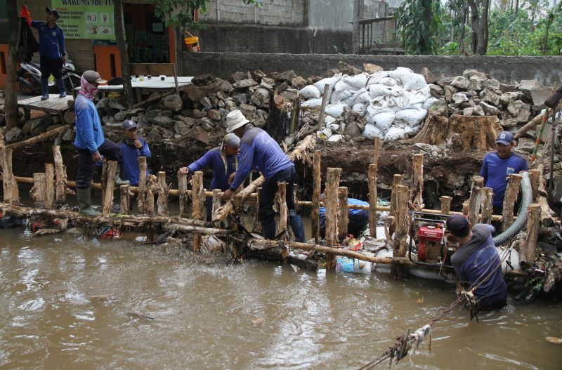 Petugas Suku Dinas Sumber Daya Air Jakarta Selatan mengerjakan proyek perbaikan turap untuk mengantisipasi banjir di Kali Cabang Tengah, Jagakarsa. /Antara Foto