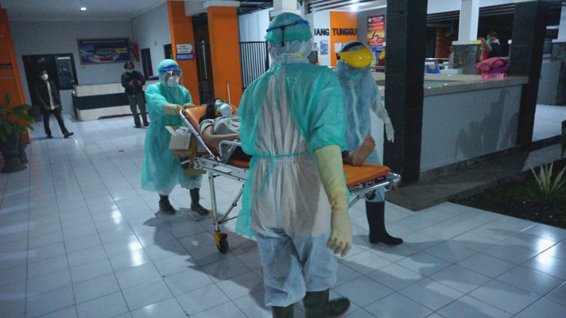 Perawat mengenakan baju hazmat membawa PDP Covid-19 menuju kamar isolasi khusus RSUD dr. Iskak, Tulungagung, Jatim, Jumat (13/3/2020). Foto Antara/Destyan Sujarwoko.