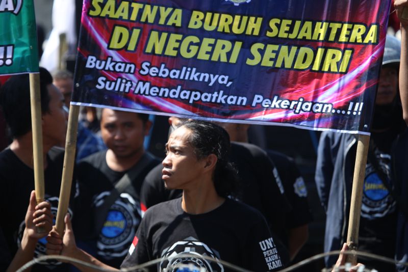 Sejumlah mahasiswa dan buruh berunjuk rasa tolak Omnibus Law Rancangan Undang Undang (RUU) Cipta Kerja di Bundaran DPRD Jember, Jawa Timur, Kamis (19/3/2020). Dalam aksinya mereka menuntut DPRD Jember menyuarakan penolakan RUU tersebut ke Pemerintah Pusat karena merugikan buruh. ANTARA FOTO/Wahyu/sen/wsj.
