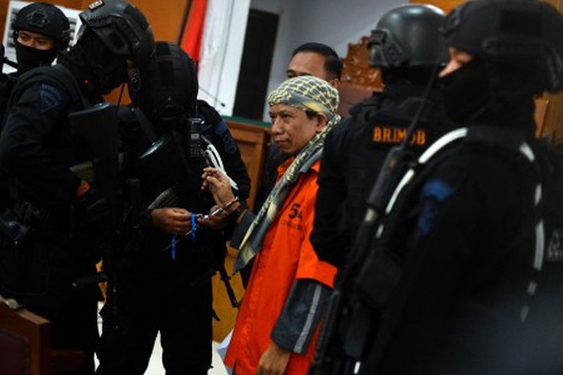Petugas memborgol tangan terdakwa kasus dugaan serangan teror bom Thamrin dengan terdakwa Oman Rochman alias Aman Abdurrahman seusai menjalani sidang lanjutan di Pengadilan Negeri Jakarta Selatan, Jumat (25/5). /Antara foto
